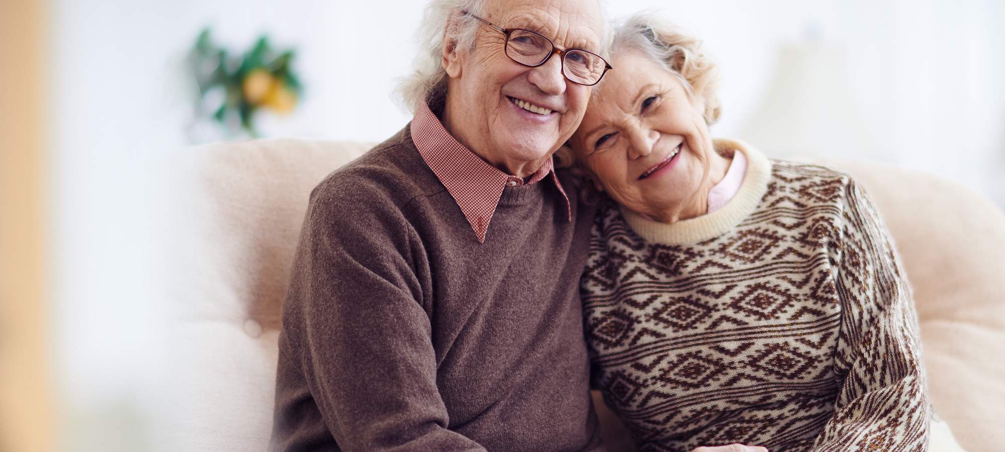 Older couple smiling together on a couch